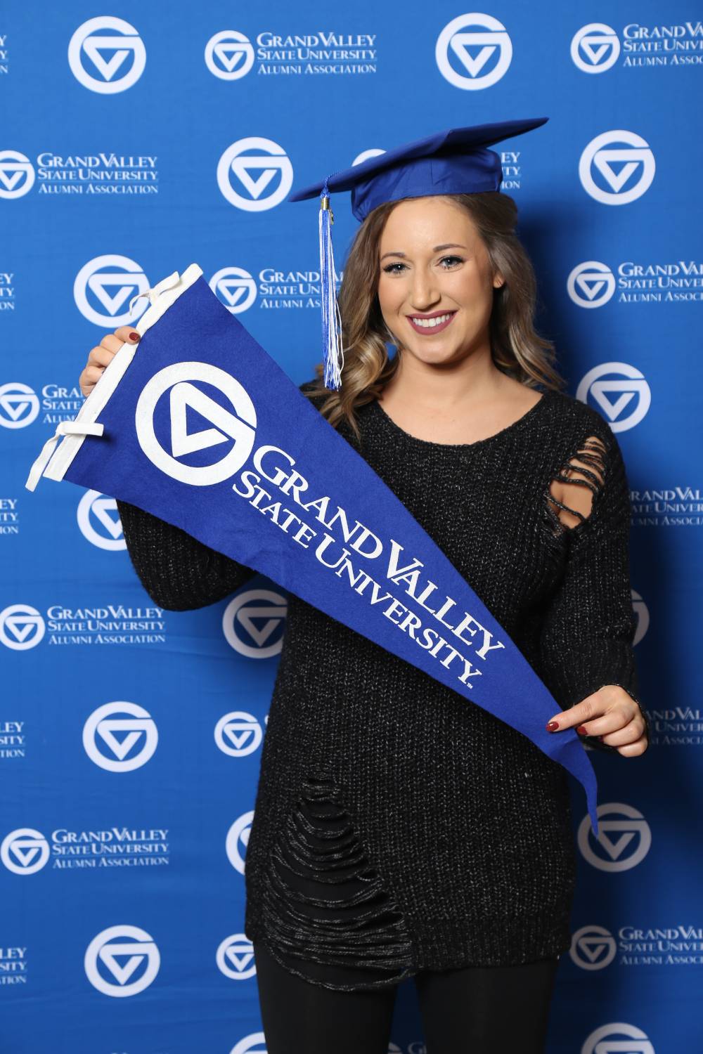 Upcoming graduate poses with GV flag at Gradfest
